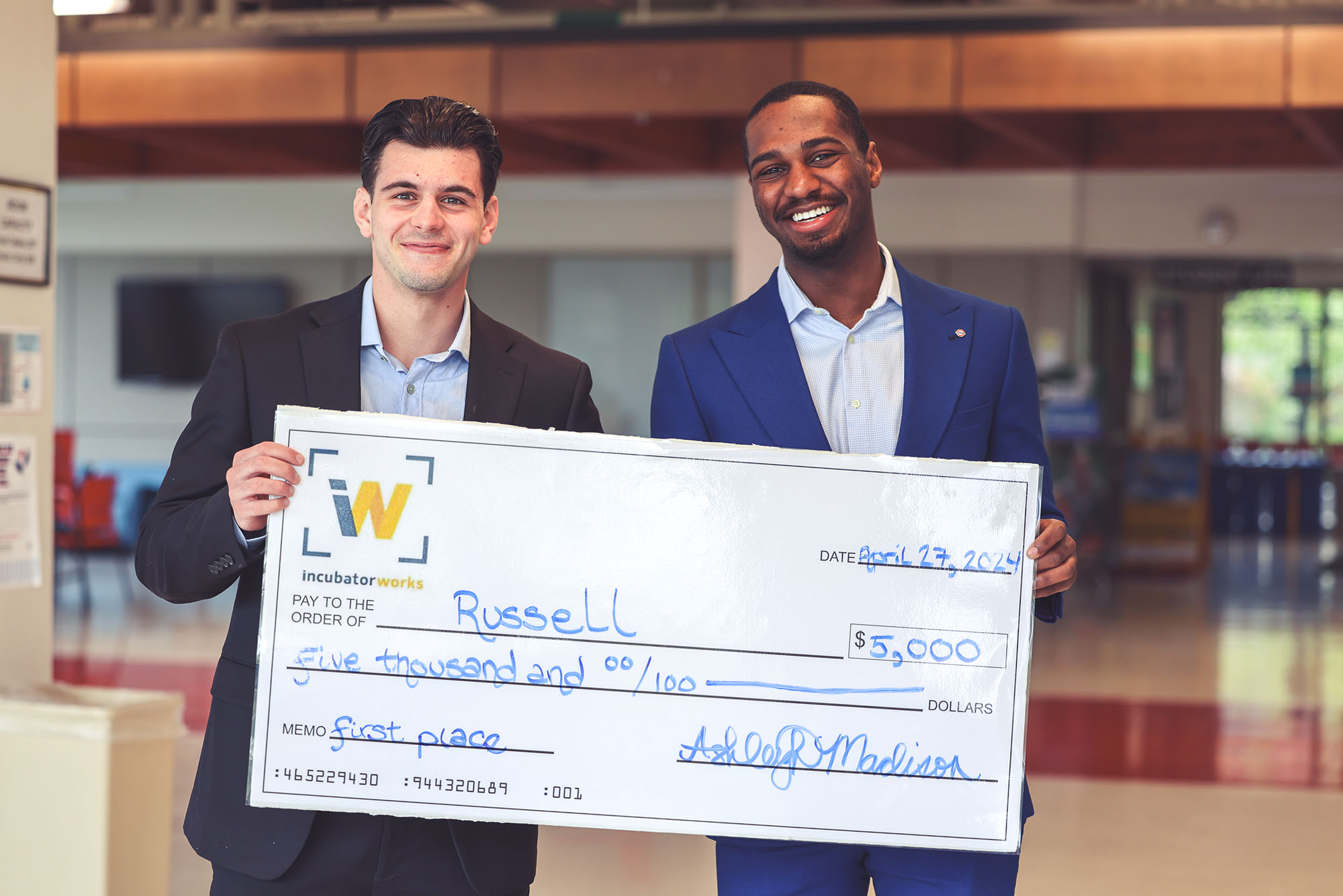 Two young men hold a check for $5,000 from IncubatorWorks